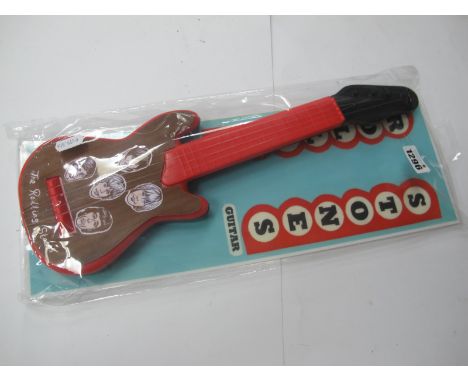 A Rolling Stones Plastic Guitar, in original packing, 41cm high.