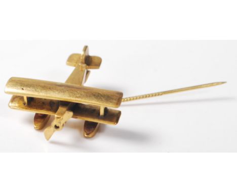 A vintage mid 20th Century trench art style git stick pin having a large finial in the form of a Bi -Plane, the pin having a 