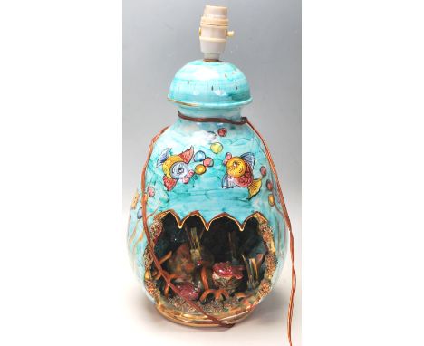 A vintage 1950’s Majolica sea shell lamp / desk lamp of waisted form with open front revealing oceanic decoration raised on a