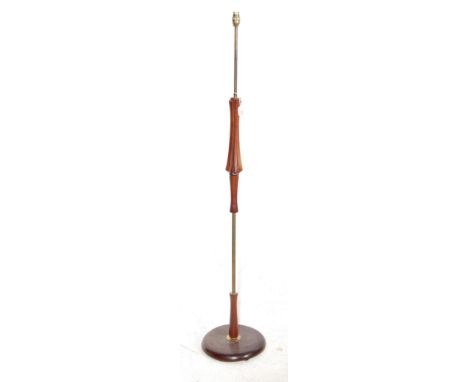 A retro vintage 1960s teak wood standard floor lamp of upright form having a pierced shaped body being set on a circular wood