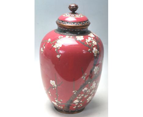 A 20th Century Chinese oriental cloisonne lidded vase having a pink ground decorated with blossom branches and perched birds,