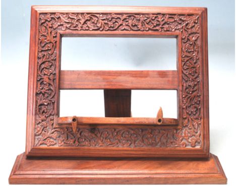 A vintage late 20th century Indian teak wood menu holder / book holder having foliate carved motifs to the margins, shaped fl