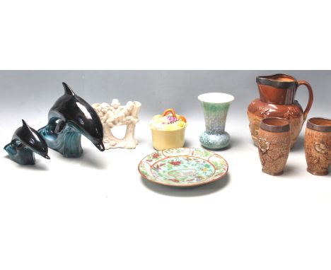 A collection of ceramics to include&nbsp; Poole Pottery dolphins, Sylvac vase, silver rimmed Harvest Jug, silver collar stone