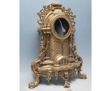 A 20th Century antique cast brass clock case of French rococo style having a round recess to the top above a curved panel wit