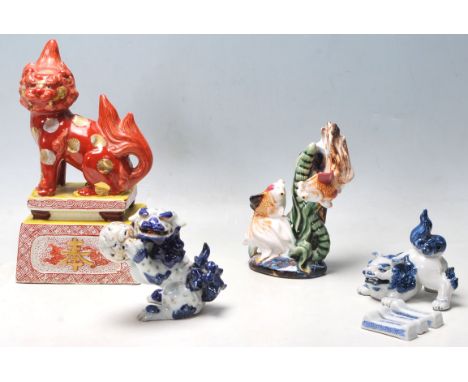 A group of early 20th century oriental Japanese ceramic figurines to include a large temple dog lion raised on a plinth base 