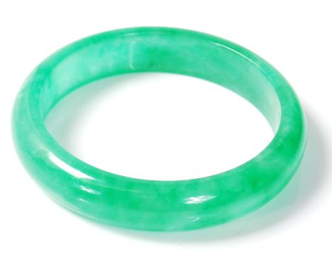 A 20th century chinese polished heard green stone bracelet / bangle of circular form. Diameter 8cm.