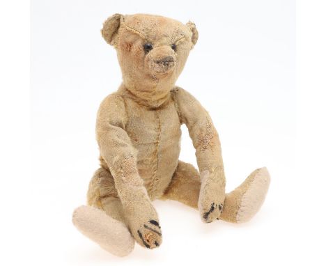 A small early 20thc Steiff Teddy Bear with elongated limbs, hump back and boot button eyes. With a button in one ear, 28cms h