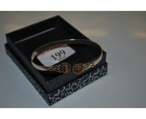 A white metal and tigers eye stone set bangle 