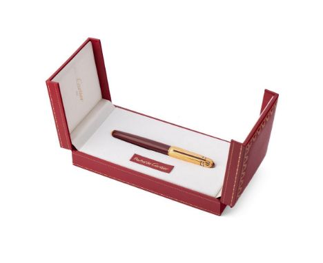 Cartier, Pasha de Cartier, a roller ball pen, with gold plated ribbed cap, red cabochon and burgundy composite barrel, in its
