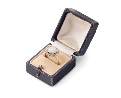 An 18ct gold, opal and diamond dress ring, the single circular opal cabochon of approximately 10mm diameter, surrounded by fo