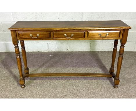 A modern varnished three drawer hall console table, with turned legs and a stretcher