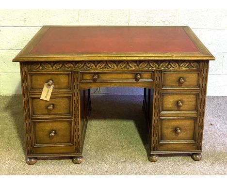 A vintage Jacobean style oak desk, 20th century, with red leathered top, over arrangement of drawers, 77cm high, 122cm wide
