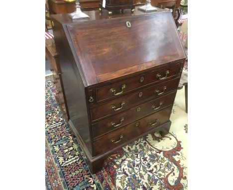 George III mahogany bureau of small proportions, with fitted interior and four long graduated drawers each with original bras