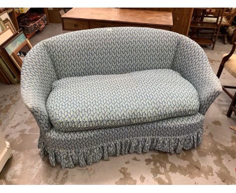 Victorian-style kidney shaped two seater sofa upholstered in leaf patterned fabric on blue ground