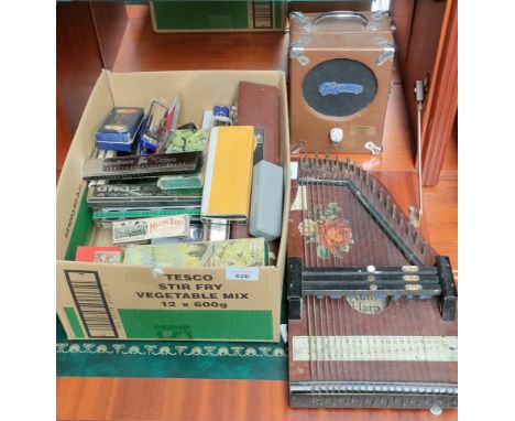 Box full of mouth organs/ harmonicas, Pignose amplifier and zither. 