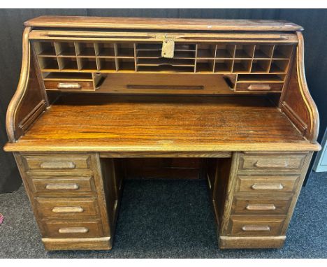 Early 20th century light oak roll top desk, the tambour front opening to display compartments and writing surface, flanked by