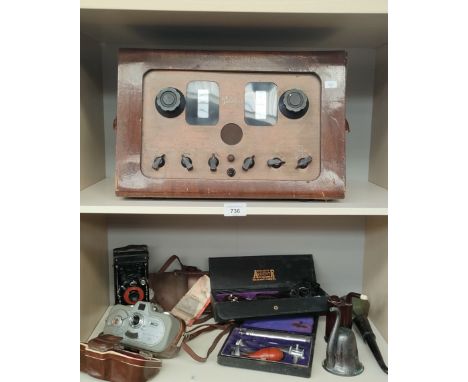 Two shelves of collectables; Movinette Zeiss Ikon Cine Camera, Various Military hearing utensils and equipment and Belclere r