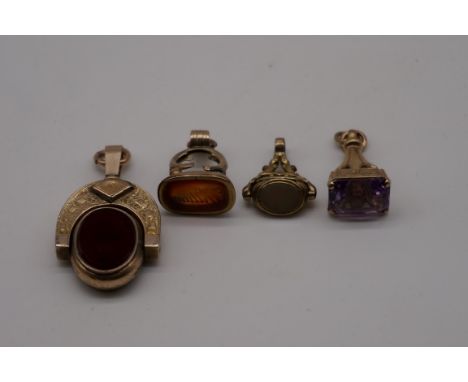An onyx and gold swivel fob, stamped 10k; together with an amethyst set fob seal, hallmarked 375; and two other base metal ex