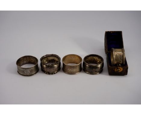 A cased silver napkin ring, by Martin, Hall &amp; Co, Sheffield 1910; together with four other examples, 79.5g. (5) 