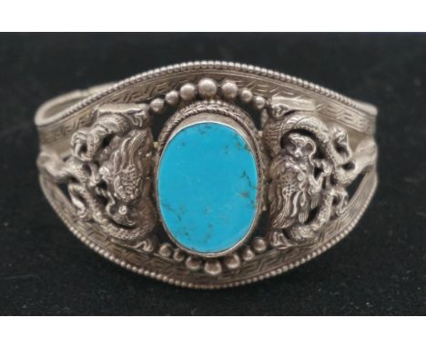 An Asian white metal and turquoise cuff bangle. 