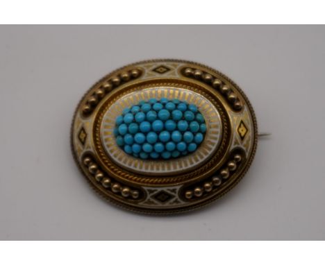 An Etruscan revival oval turquoise and enamel yellow metal mourning brooch, 43 x 33mm. 