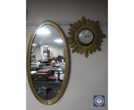An oval gilt framed mirror together with an early 20th century gilt metal sunburst wall clock with battery movement CONDITION