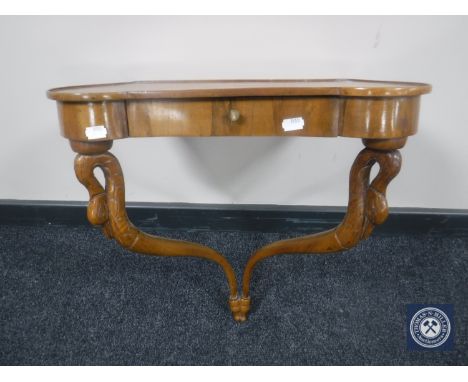 A walnut wall shelf fitted a drawer on swan neck supports