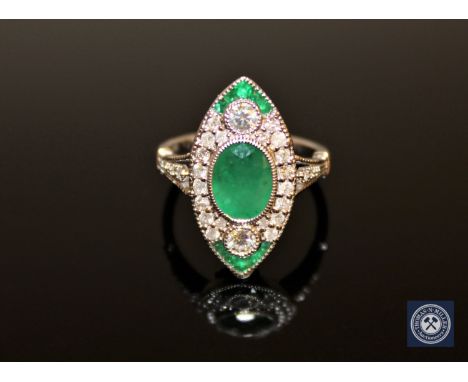 An 18ct white gold emerald and diamond ring, the central oval-cut emerald of medium-green colour weighing 1.23 carat, surroun