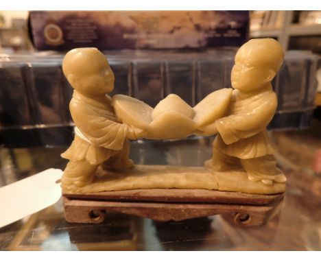 Oriental carved soapstone of two children carving a lotus flower A/F   CONDITION REPORT: Base has crack in front of flight ha