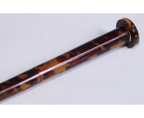 An early 20th century tortoiseshell walking cane, the circular pommel inlaid in mother of pearl with a four-pointed star, the