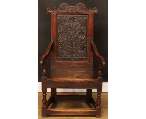 A late 17th century and later oak wainscot armchair, shaped cresting rail carved with leaves and scrolls, rectangular back pa