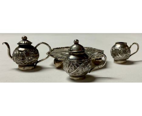 A Chinese silver miniature three piece tea service on tray, chased with leafy bamboo,the octagonal tray 6cm diam, character m