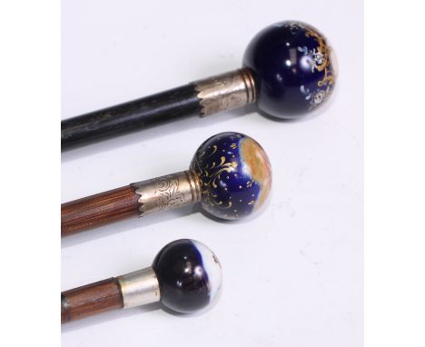 A Continental porcelain mounted walking stick, globular pommel decorated with a putto scattering flowers, silver bound cane, 