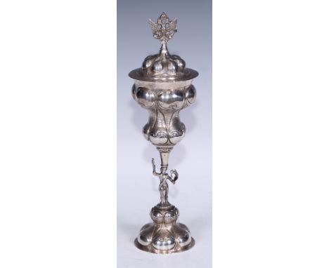 A Russian silver standing cup and cover, lobed and chased with scrolls, figural stem, crowned double-eagle finial, 32cm high,