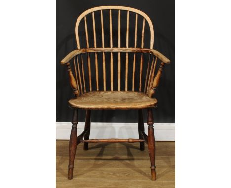 A 19th century beech and elm stick back Windsor elbow chair, hoop back, one-piece mid-rail, turned arm posts, saddle seat, tu