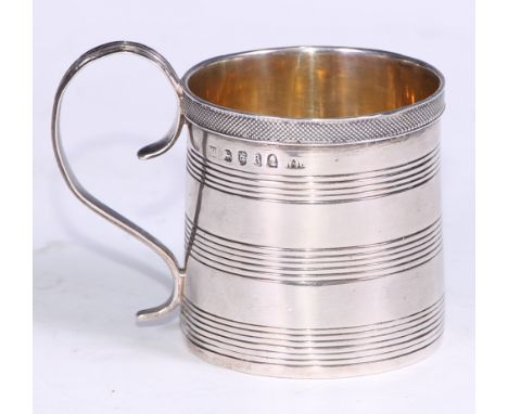A George III silver cylindrical child's mug, applied engine turned rim above three reeded bands, conforming scroll handle, gi
