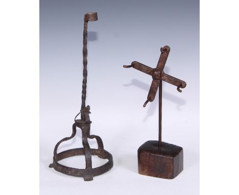 An unusual 19th century wrought iron tallow holder or candlestick, twisted stem, circular base with arched supports, 35.5cm h