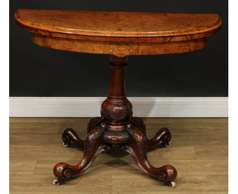 A Victorian walnut demilune card table, hinged top with bookmatched veneers enclosing a baize-lined playing surface, turned c