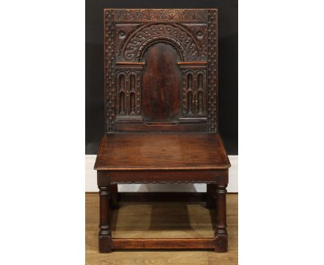 A 17th century style oak child’s wainscot side chair, the back carved with a frieze of lunettes above an architectural arch, 