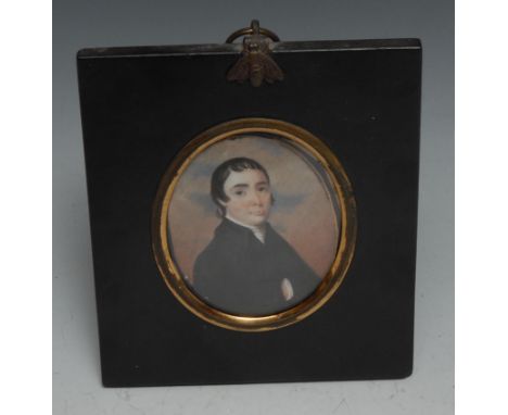 English School (19th century), a portrait miniature, of a gentleman, with curling black hair, his hand inside his black coat,