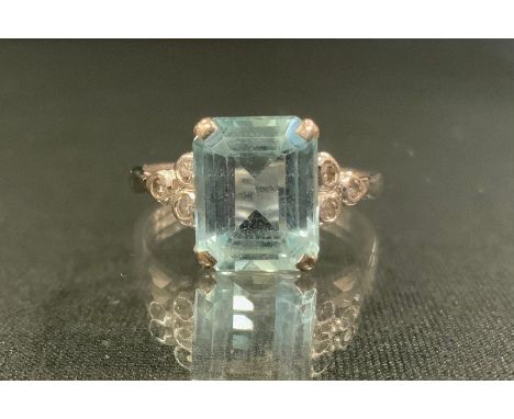 A diamond and aquamarine ring, rectangular octagonal cut aquamarine, measuring, 9.7mm x 8mm x 4.7mm, between three stone bril