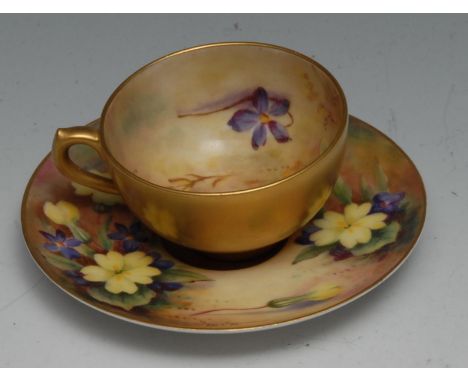 A Royal Worcester cabinet cup and saucer, decorated with primrose and violets on a mossy ground, printed crown and circle mar