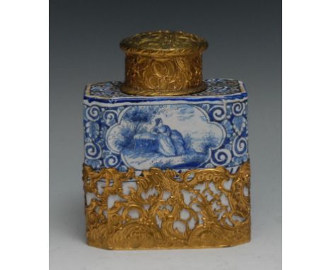 A Dutch Delft canted rectangular tea caddy, painted in tones of blue with figures and landscape vignettes, Rococo gilt metal 