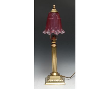 A brass table lamp, fluted pillar, square base with acanthus border, cranberry-type glass shade, 50cm high 