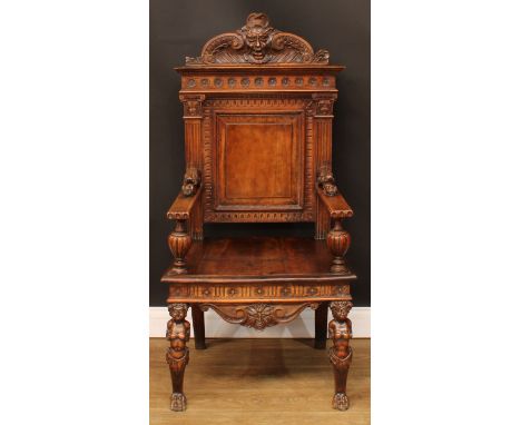 An Italian Renaissance Revival walnut armchair, shaped cresting carved with a Green Man mask, panel back, the forelegs carved