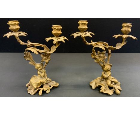 A pair of 19th century Rococo Revival ormolu two-light mantel candelabra, cast with a young courting couple, reclining to lef
