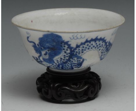 A Chinese circular bowl, painted in tones of blue picked out in manganese with a ferocious dragon chasing a flaming pearl, 12