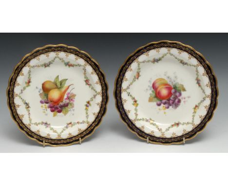A pair of Royal Worcester shaped circualar plates, painted by by E. Phillips, signed, with ripe fruit, within swags, blue and