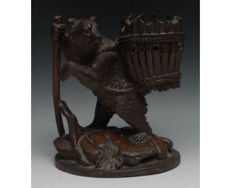 A 19th century Black Forest carved spill vase,  as a bear with a walking stick,  carrying a basket, 23cm high, c.1880 