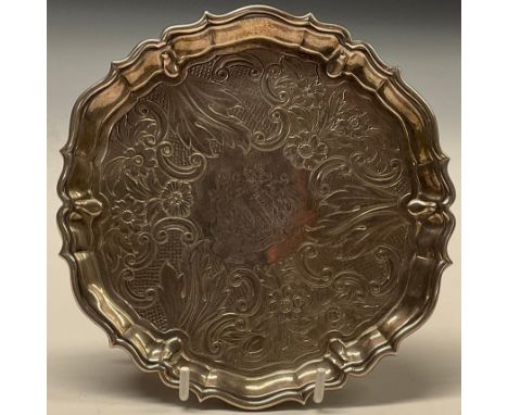 A George II silver shaped circular waiter, fluted border, the field chased with a band of flowers, C-scrolls and scales, hoof